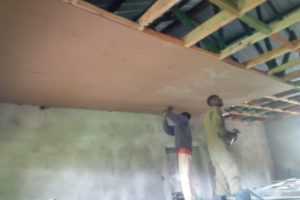 Two men installing the dormitory ceiling