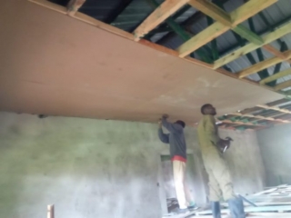 Two men installing the dormitory ceiling